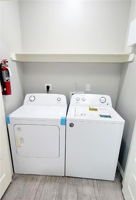 Laundry area featuring light hardwood / wood-style flooring and independent washer and dryer