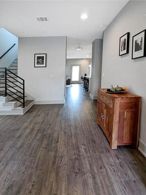 Corridor with dark wood-style floors, stairs, bas