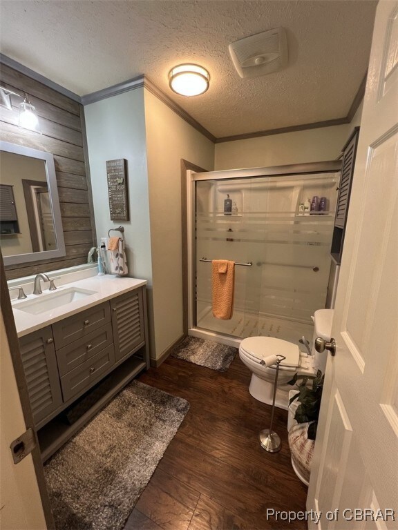 Bathroom with a shower stall, wood finished floors