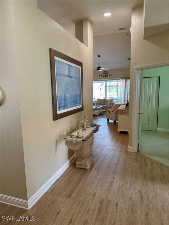 Hallway featuring baseboards, wood finished floors