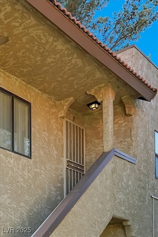 View of side of property featuring a tiled roof an