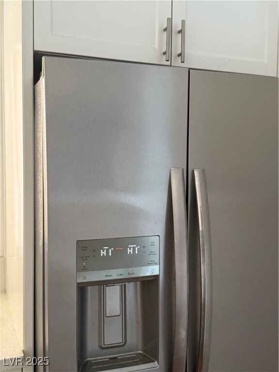Kitchen view of stainless steel fridge and white c