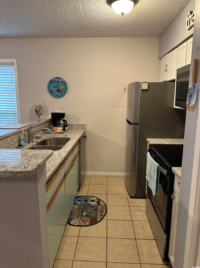 Kitchen featuring white cabinets, dishwasher, sink