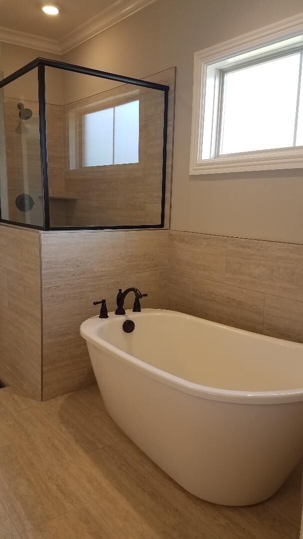 Standalone tub and spacious ceramic shower.  Notice the 12 x 24 tile!