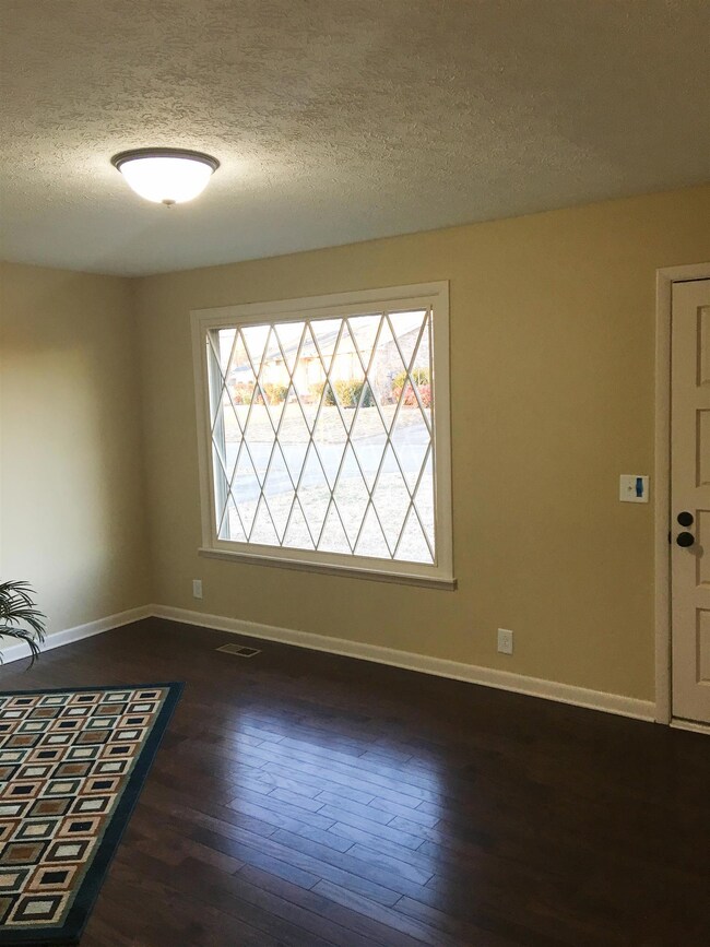 This home features all new finished wood flooring in a warm walnut throughout. Wonderful picture window overlooks front yard, diamond grid. 