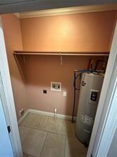 Laundry room with baseboards, electric water heate