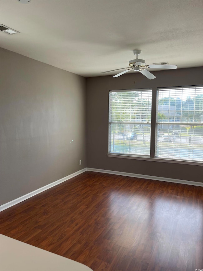 Empty room with dark wood finished floors, visible