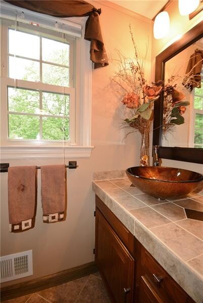 Half bath off of foyer is beautifully tiled with a