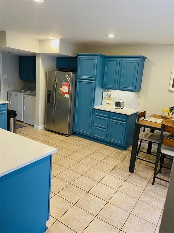 Kitchen with blue cabinets, washer and dryer, ligh