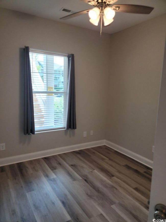 Spare room with wood finished floors, a ceiling fa
