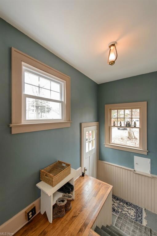 Charming back entry way that leads you up into a wonderful country kitchen.  The wood floors, bead board wainscoting and high ceilings make this area very inviting.