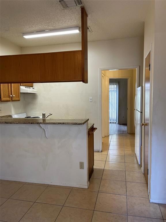 Kitchen featuring freestanding refrigerator, brow