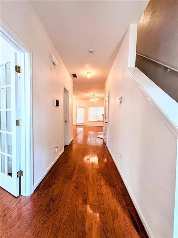 Hallway featuring baseboards, visible vents, and h