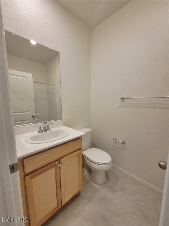 Bathroom with vanity, toilet, and tile patterned f