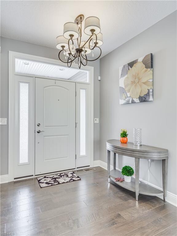 Foyer with hardwood floors, beautiful light fixture