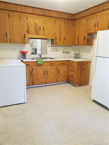 Kitchen with a fridge and washer and dryer. Stove 