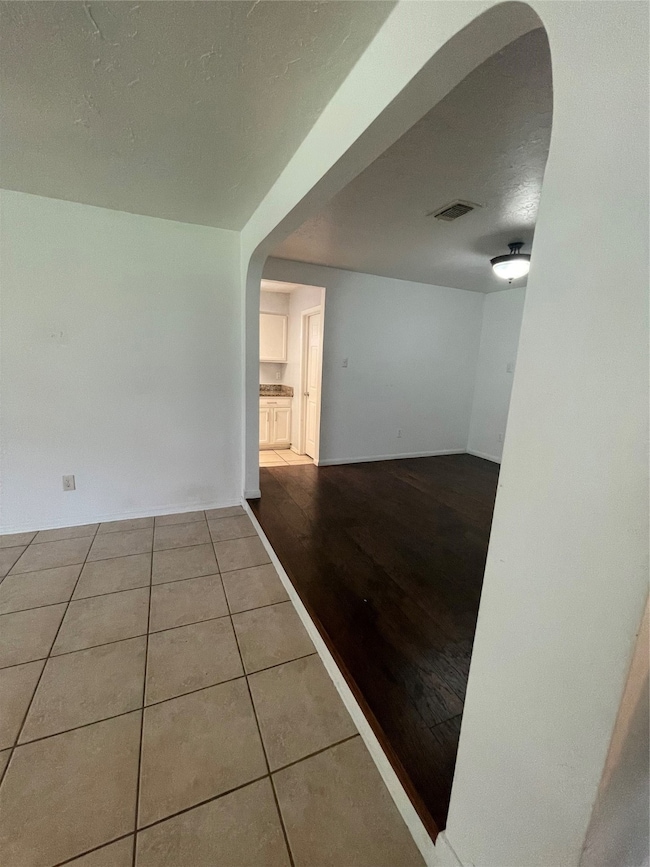 Den area, separated by an arched doorway. Leads to