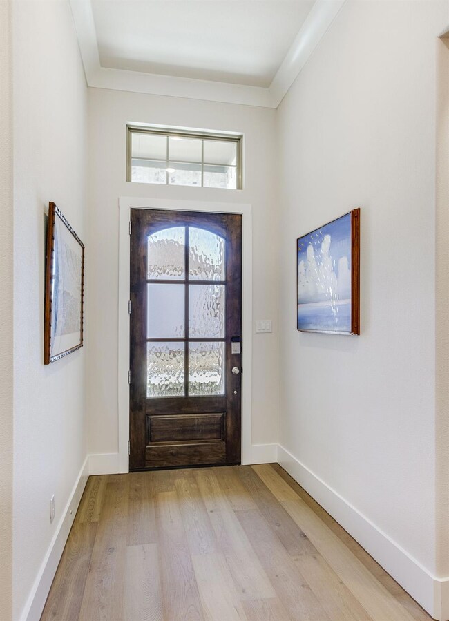 Elegant mahogany front door with Flemish glass panels allow for a light and bright entryway.