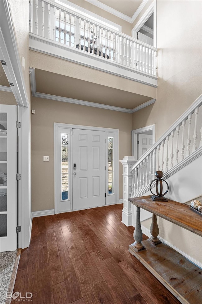 Foyer entrance featuring baseboards, a towering ce
