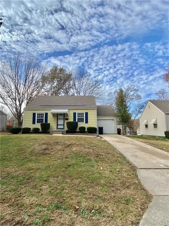 Ranch-style house with a front lawn, concrete driveway, and a garage