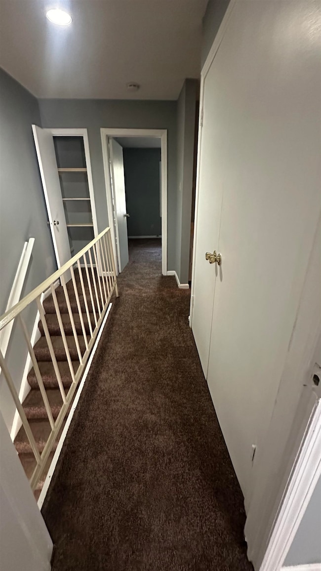 Corridor featuring carpet floors and baseboards