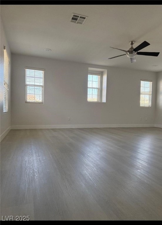 Empty room with a ceiling fan, light wood-style fl