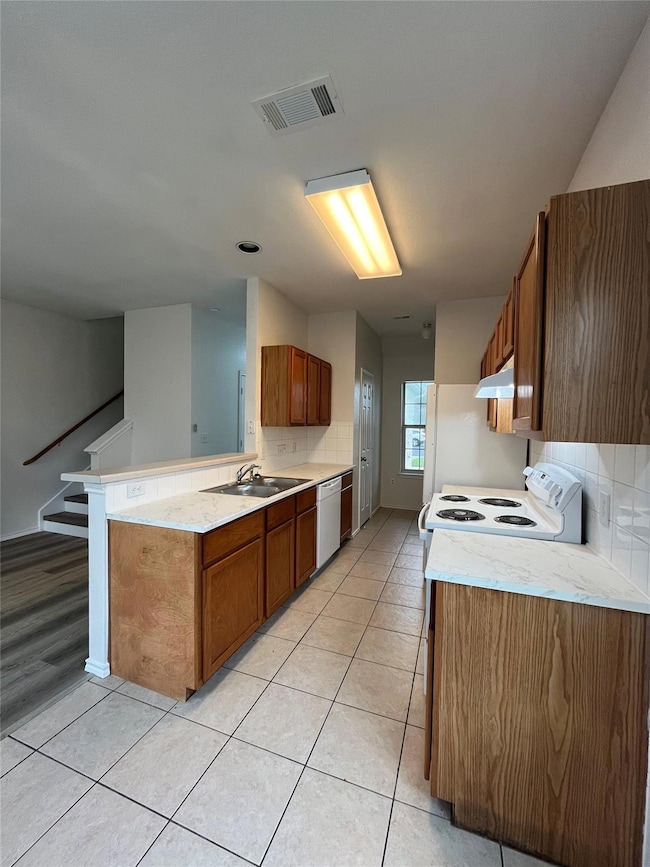 Kitchen with white appliances, a sink, decorative