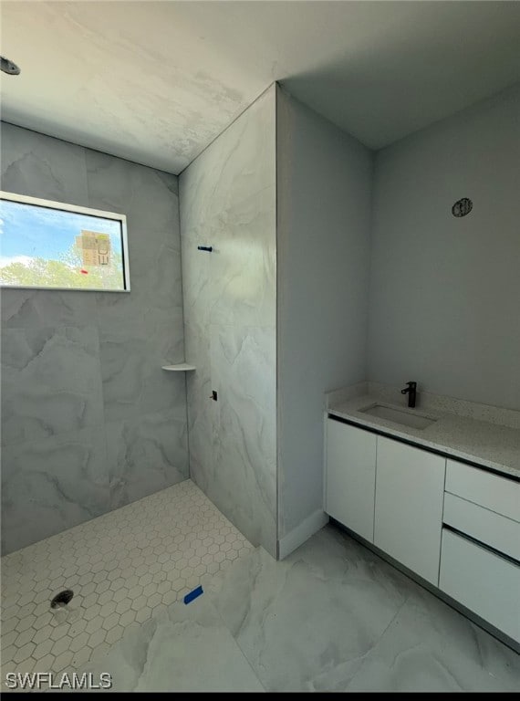Bathroom featuring vanity, a marble finish shower,