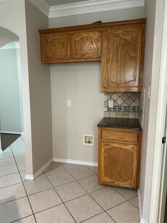 Kitchen with decorative backsplash, dark stone cou
