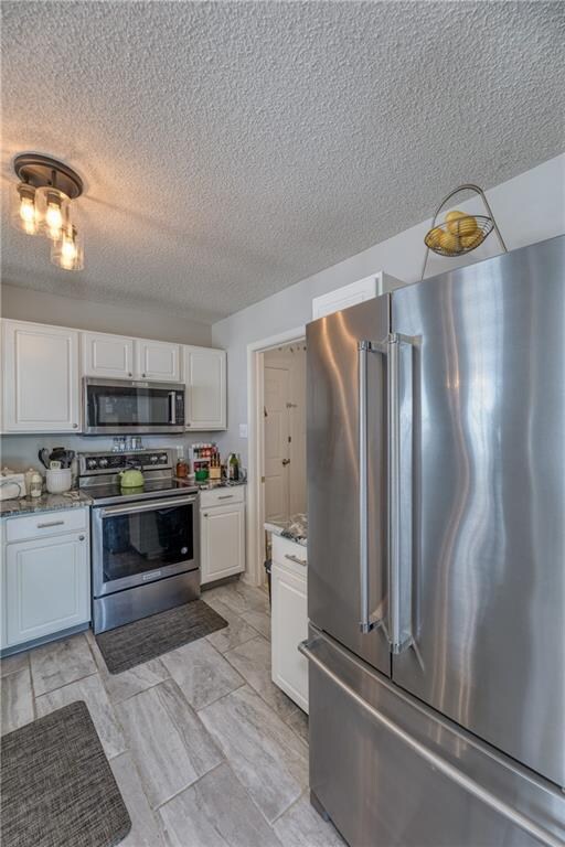 KITCHEN:  Updated Kitchen features updated Cabinets and Granite Countertops, Sink and Fixtures, Tile Flooring and SS Appliances.