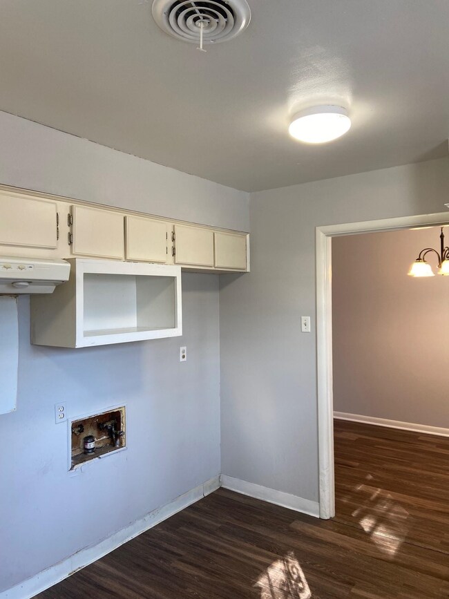 Washroom featuring dark wood-style floors, baseboards, a chandelier, and hookup for a washing machine