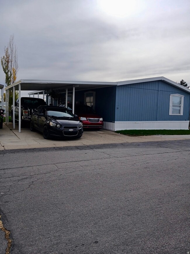 View of building exterior with an attached carport and driveway