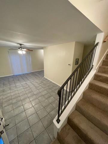 Stairs with baseboards and a ceiling fan