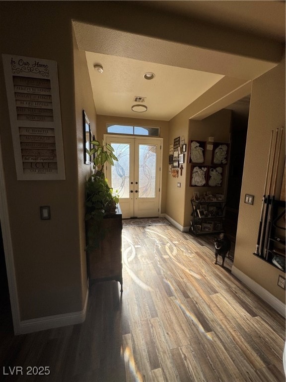 Entrance foyer with baseboards, wood finished floo