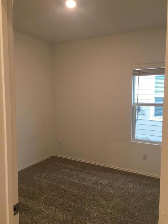 Spare room featuring dark colored carpet and recessed lighting