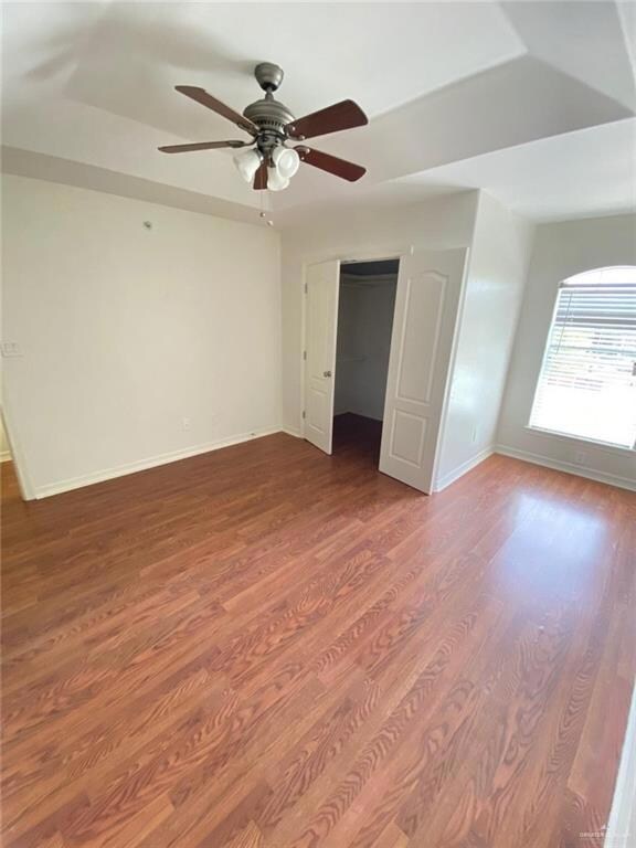 Unfurnished room featuring wood finished floors, baseboards, and ceiling fan
