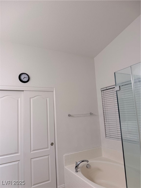 Bathroom featuring a bath and a shower stall