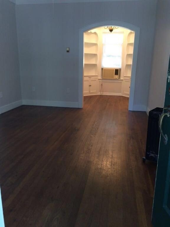 Unfurnished living room with dark wood finished f