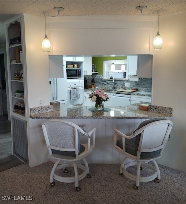 Kitchen featuring a kitchen breakfast bar, white c