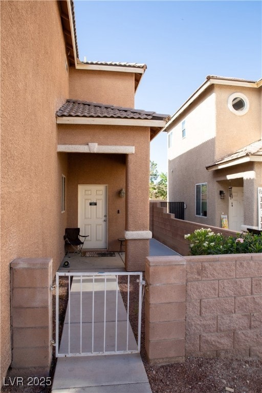 Entrance to property featuring stucco siding, a ga