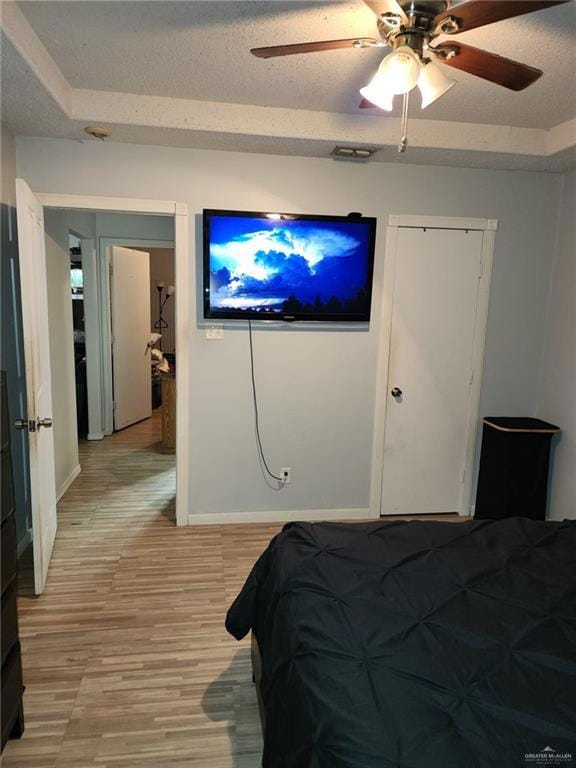 Bedroom featuring hardwood / wood-style floors, a textured ceiling, and ceiling fan