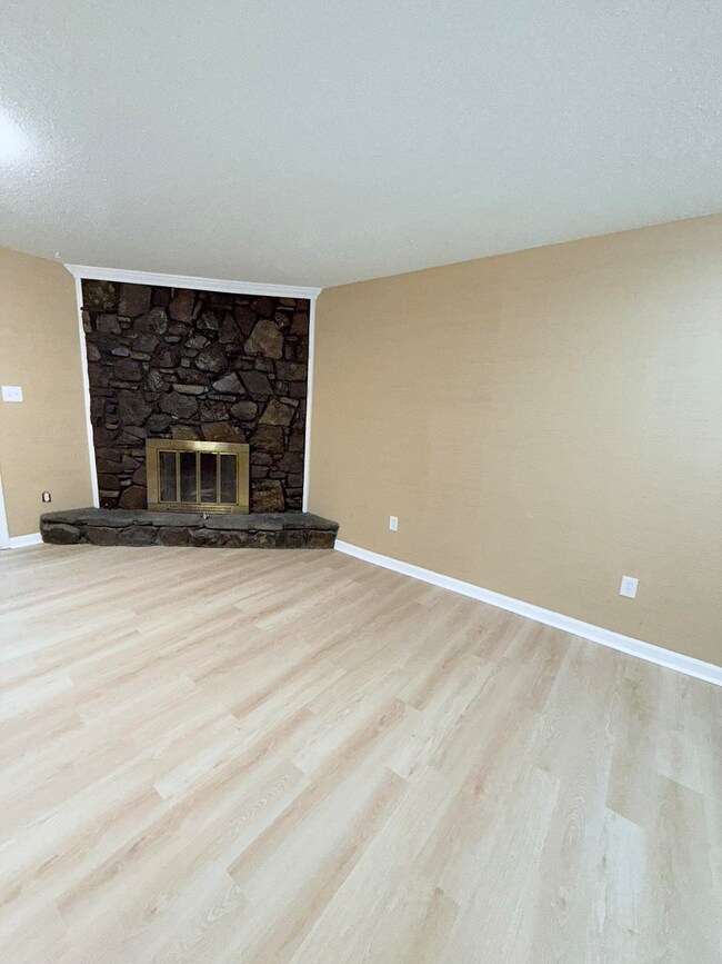 Unfurnished living room featuring a fireplace, a t