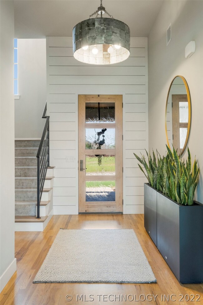 Inviting vaulted foyer boasts hardwood floors, shi
