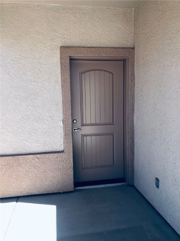 Entrance to property featuring stucco siding