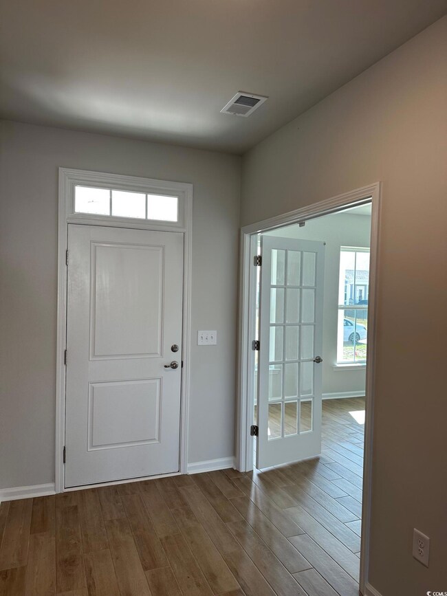 Entryway with wood finished floors, baseboards, an