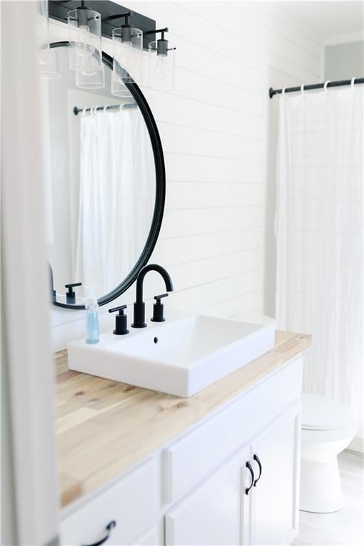 Full bathroom with toilet, curtained shower, and v