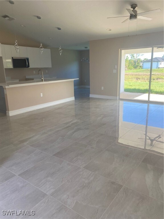 Kitchen with baseboards, light marble finish floor
