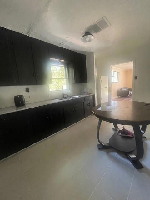 Kitchen with refrigerator, light tile patterned fl