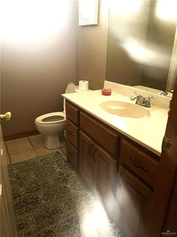 Bathroom featuring tile patterned floors, toilet, and vanity