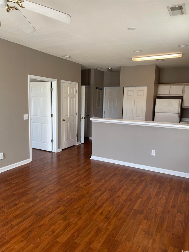 Spare room with dark wood-style floors, baseboards